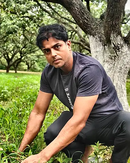 Deepak Chambial weeding by hand in the orchard